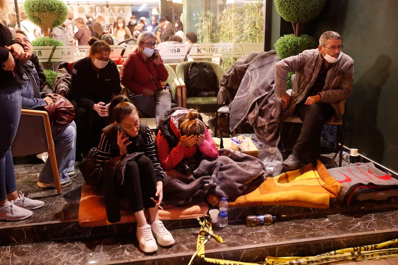 Local residents, staying outdoors for fear of aftershocks, sit in a coffee shop in Izmir, Turkey, Saturday, Oct. 31, 2020.