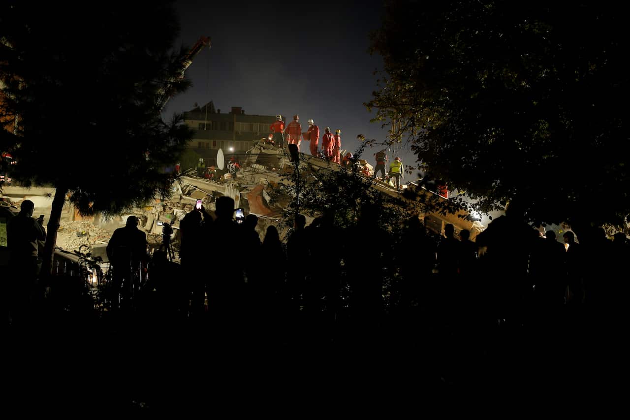 Members of rescue services search for survivors in the debris of a collapsed building in Izmir, Turkey, Saturday, Oct. 31, 2020.