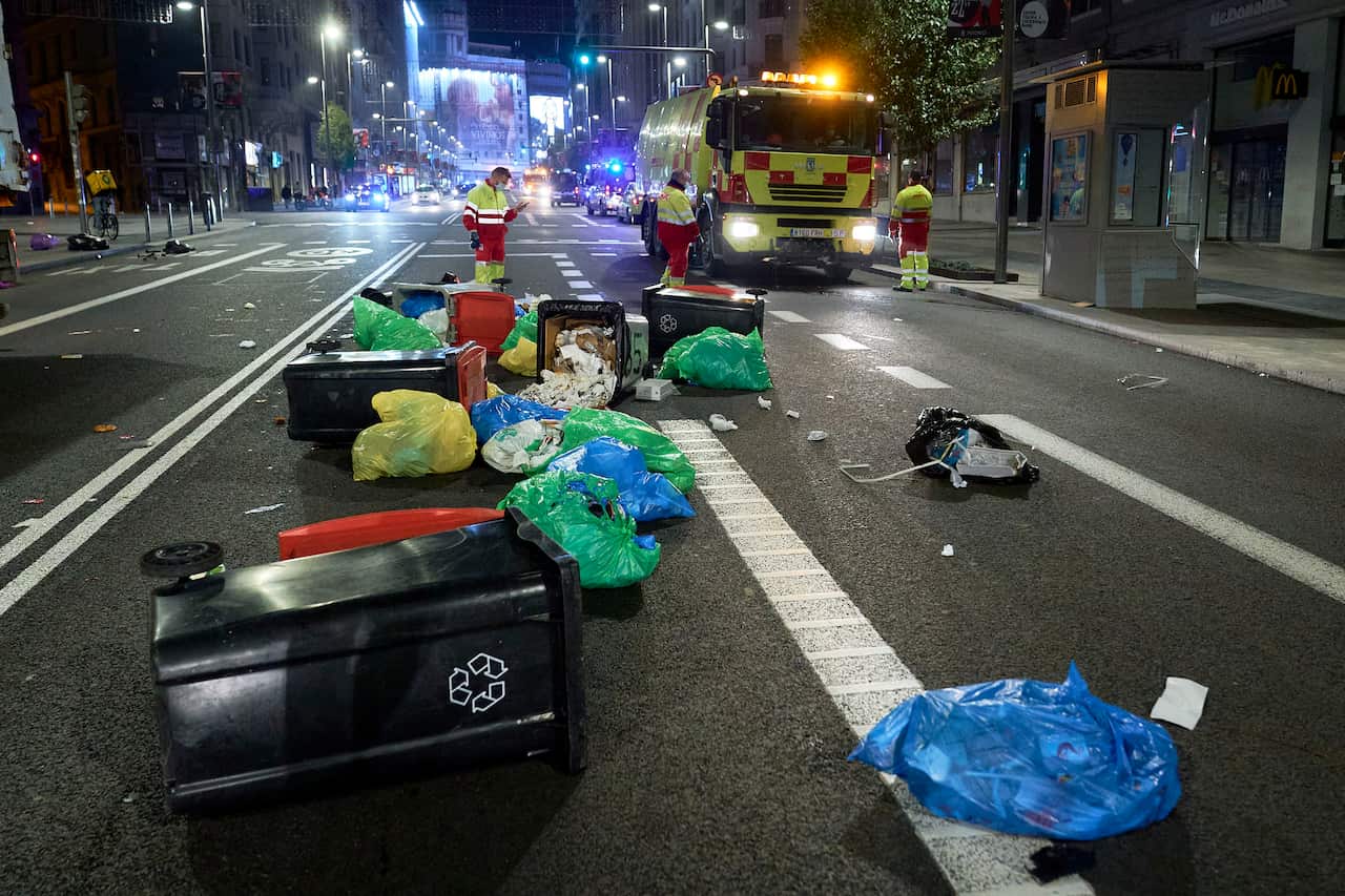 Trash bins laying on the road during protests against coronavirus restrictions in Madrid, Spain.