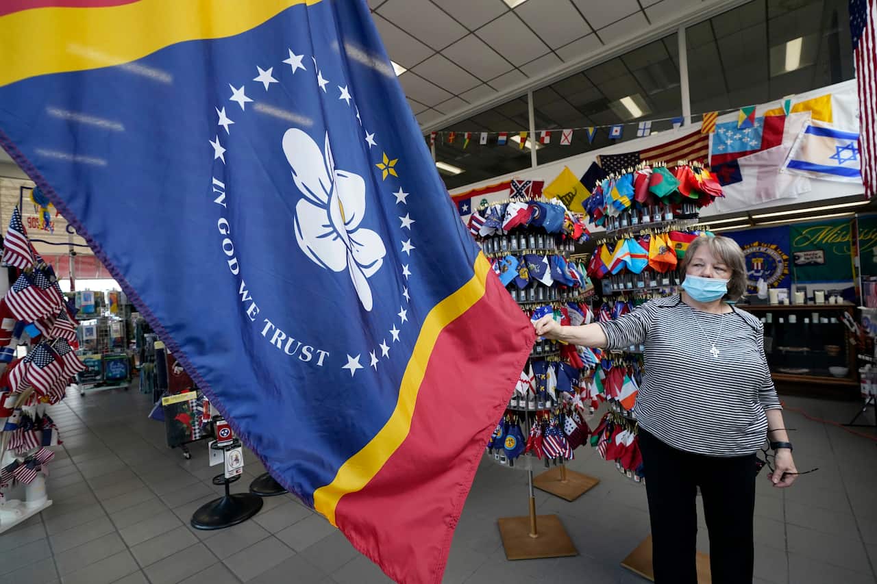 Brenda McIntyre, a co-owner of A Complete Flag Source store in Jackson, Mississippi shows off the magnolia-centered banner.