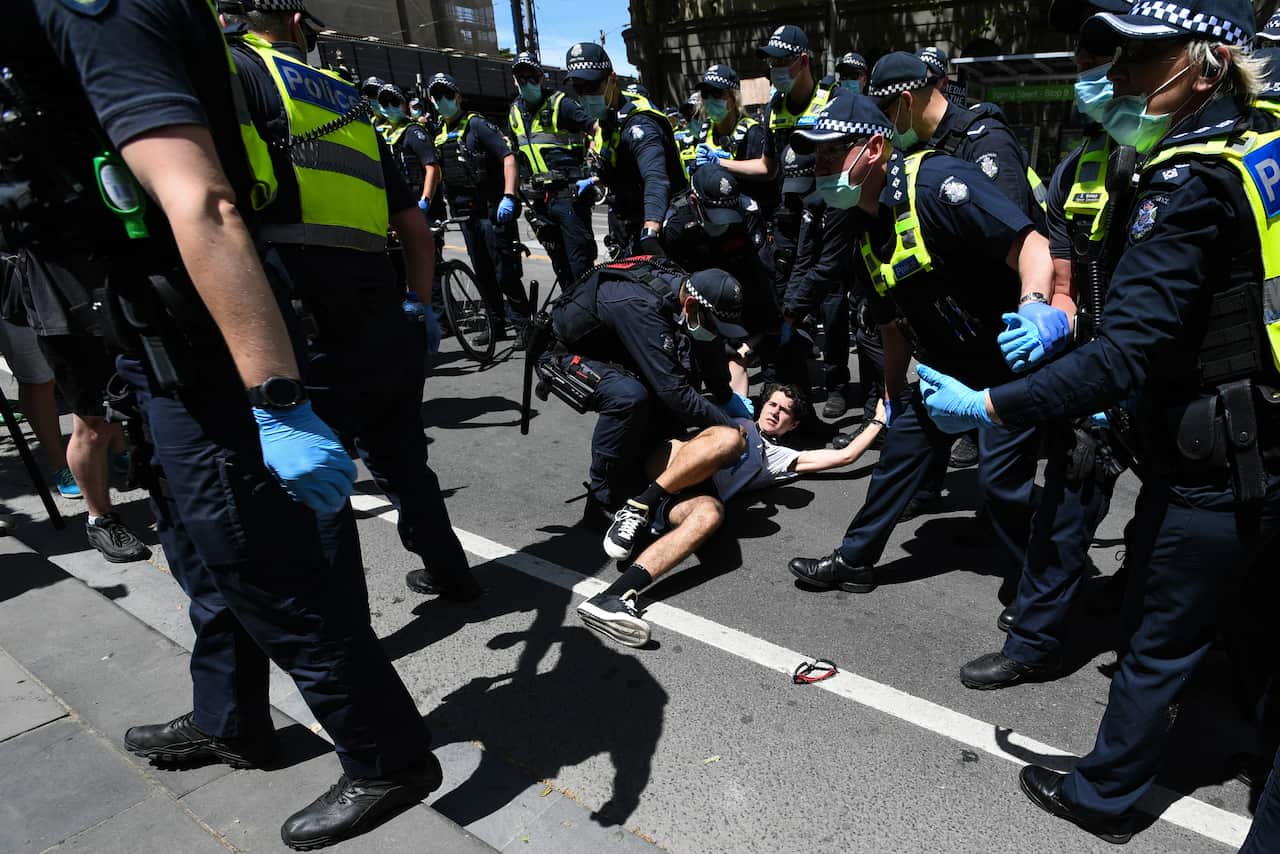 Police scuffle with protesters during an anti-lockdown protest in Melbourne.