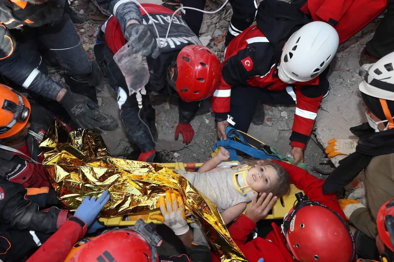 Rescue workers taking care of three-year-old survivor Ayda Gezgin