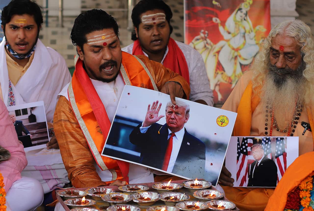 An activist of Hindu Sena performs rituals as he holds a portrait of US President Donald Trump during a prayer ceremony in New Delhi, 4 November, 2020.