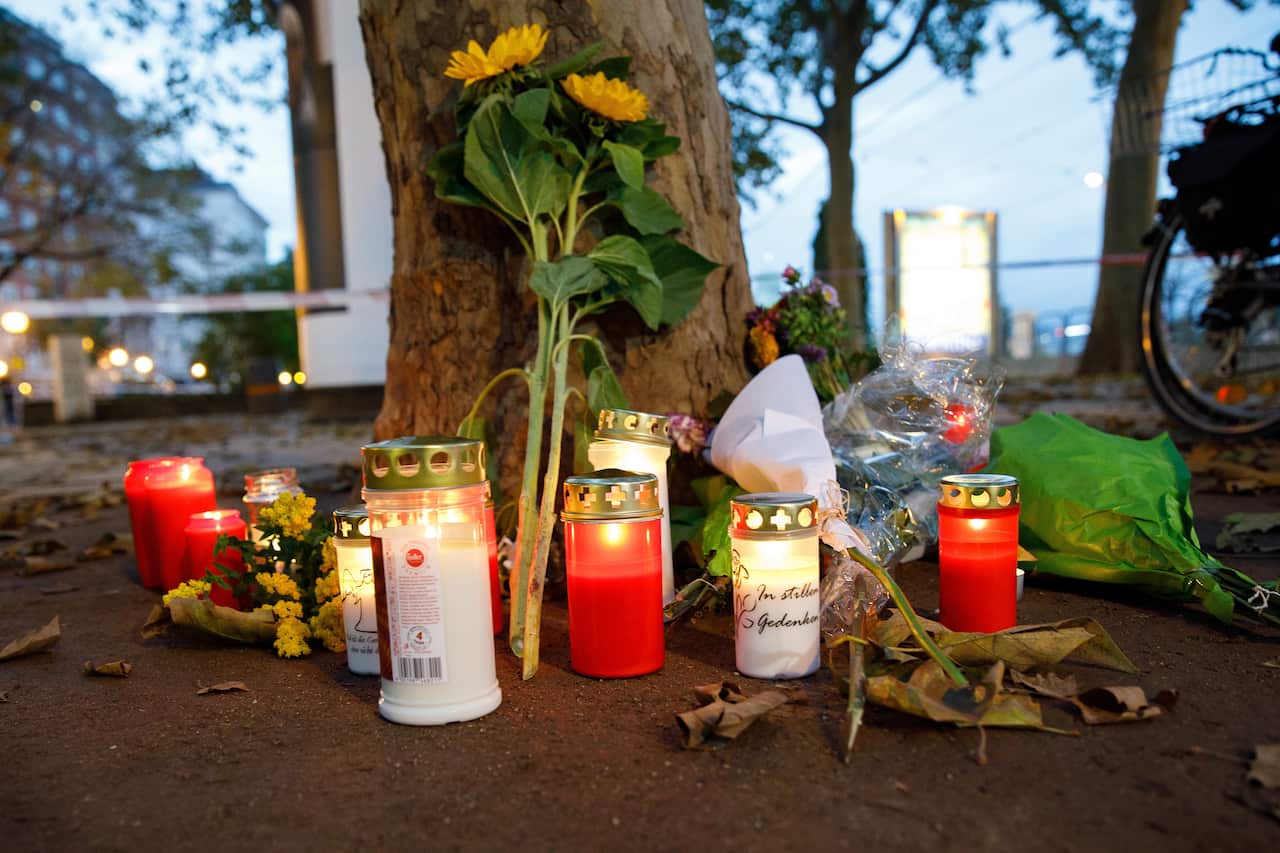 Candles and flowers are left near the crime scene where at least four people died in Vienna
