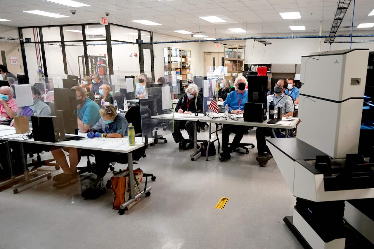 Maricopa County elections officials and observers watch as ballots are tallied.