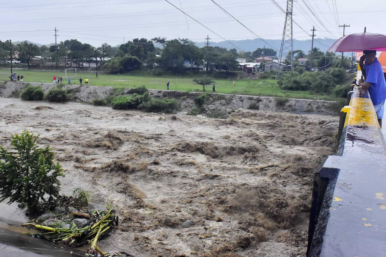 People observe the flow of the Choloma River, in Choloma, Honduras, on 4 November.