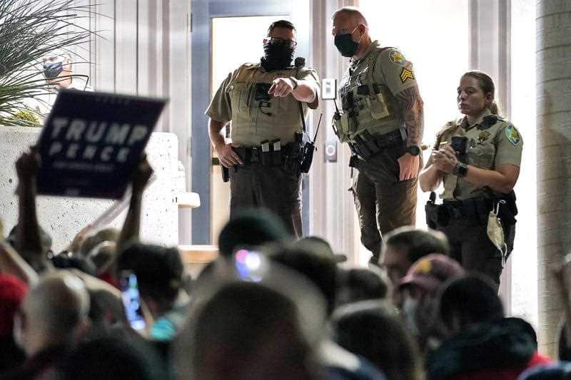Maricopa County Sheriff's Deputies stand at the door of the Maricopa County Recorder's Office as President Donald Trump supporters rally outside,