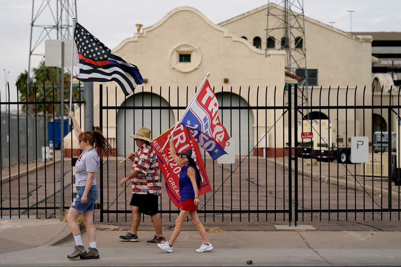 Supporters of President Donald Trump walk to a rally outside the Maricopa County Recorder's Office in Arizona.