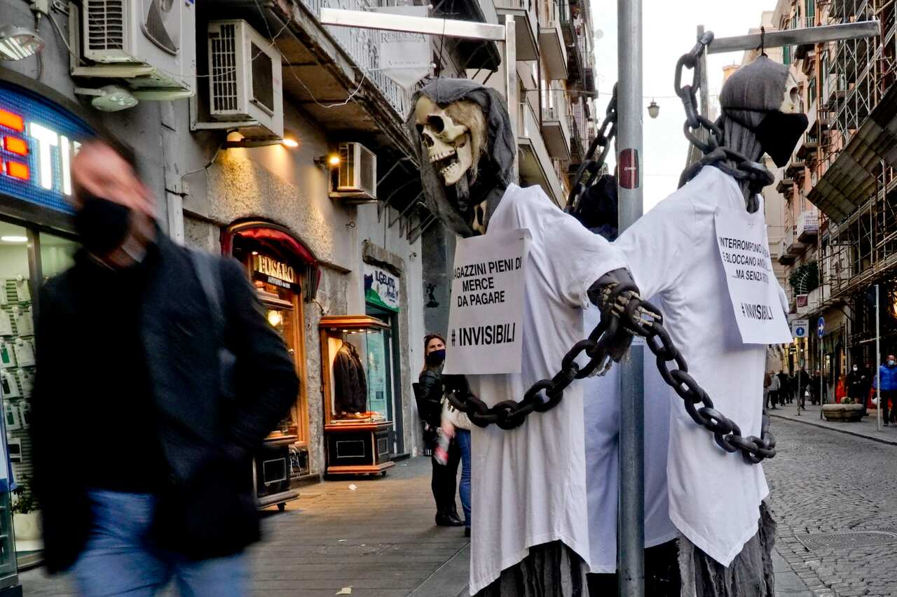 A skeleton and a banner reading 'Shame, You Kill more of us than Covid' hanging at the window of a store in via Toledo in Naples, Italy. 