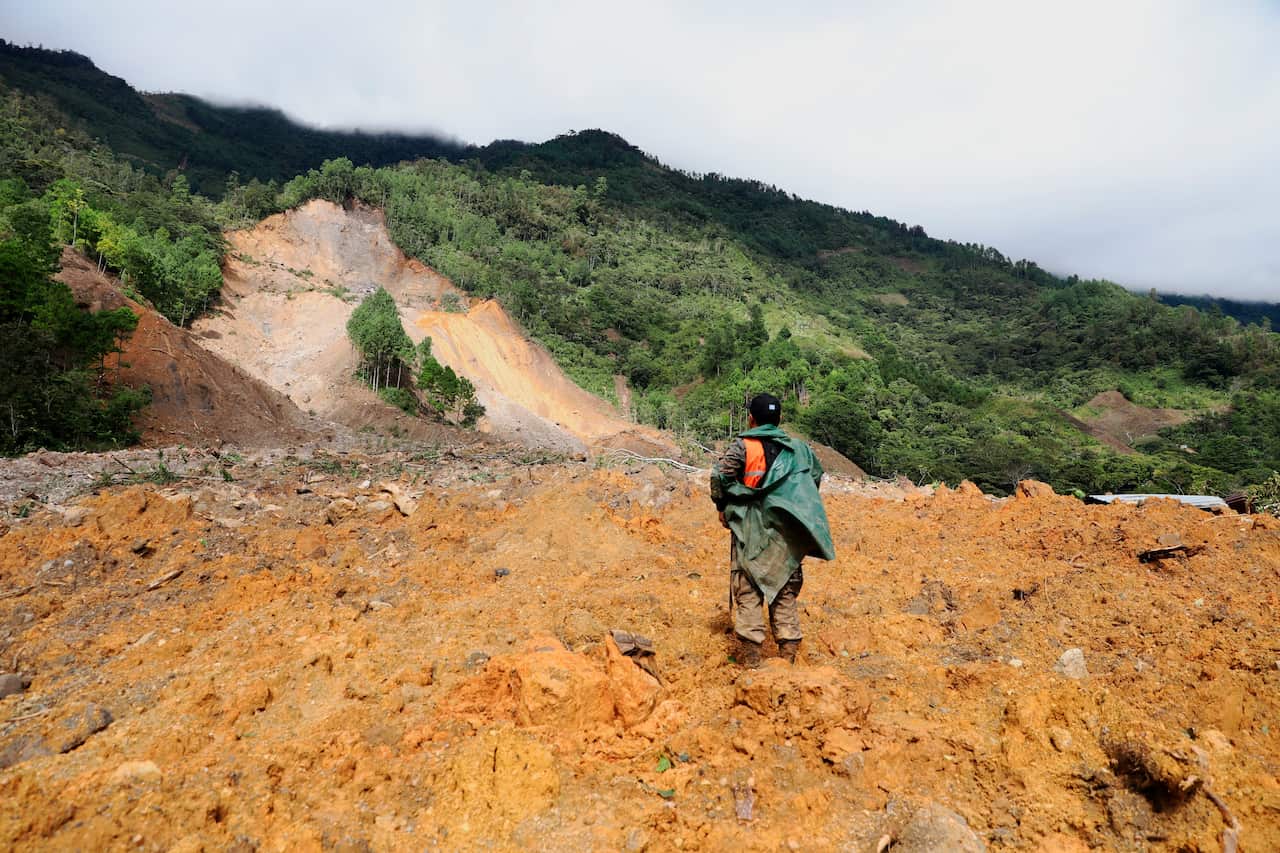 A member of a search and rescue team looks for survivors after a massive landslide in the village of Queja, in Guatemala, Saturday, 7 November, 2020.