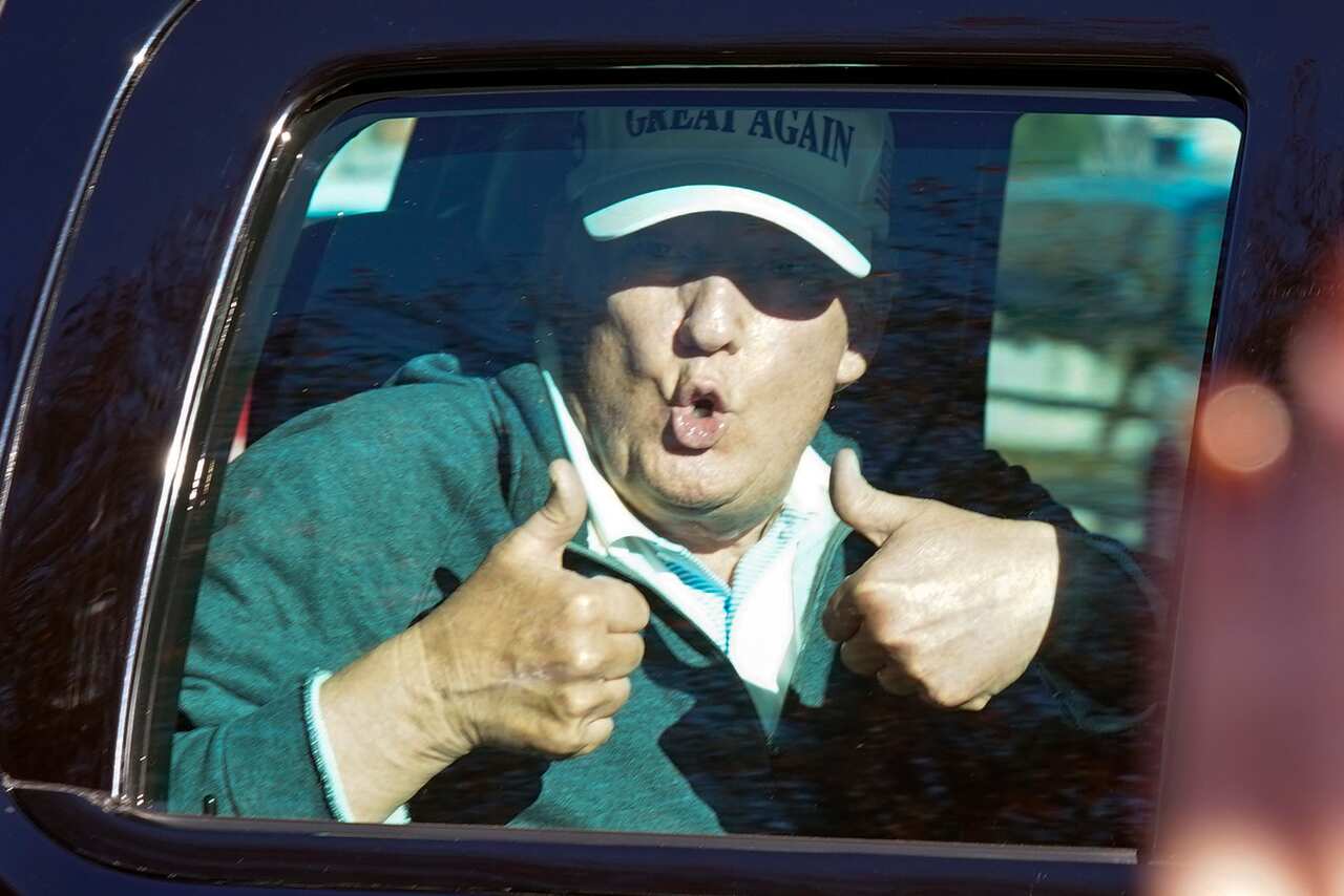 President Donald Trump gives two thumbs up to supporters his round of golf on Sunday.