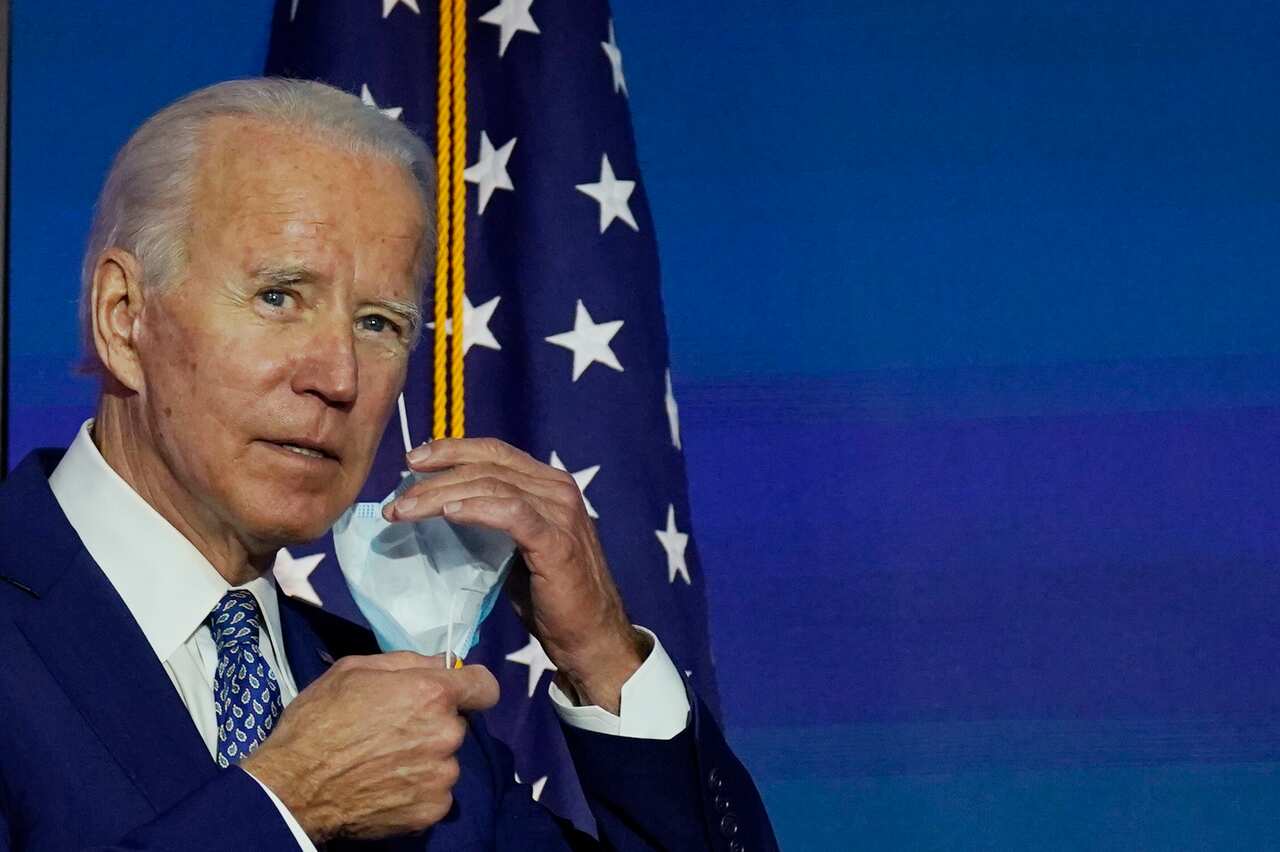 President-elect Joe Biden removes his face mask as he arrives to speak in Wilmington, Delaware.