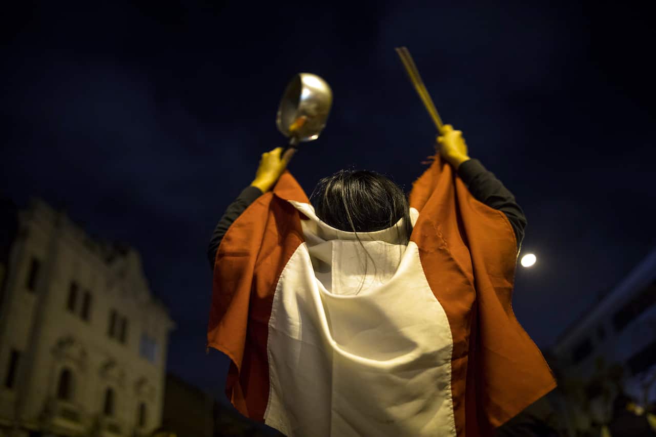 A pro-government protestor hits a pot during a protest near the Congress in Lima, Peru, 9 November, 2020.