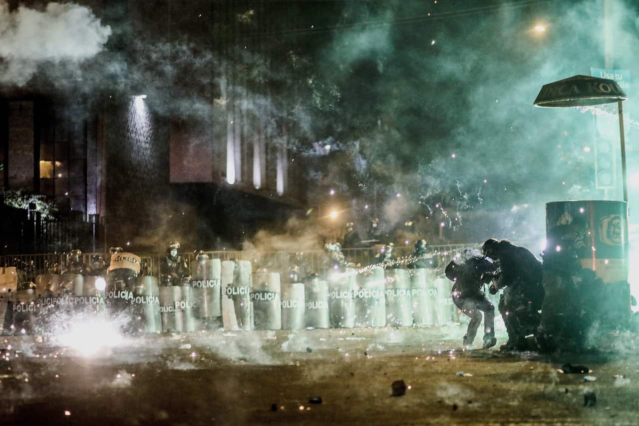 Police officers fire tear gas canisters at demonstrators at Plaza San Martin in Lima, Peru, 12 November 2020