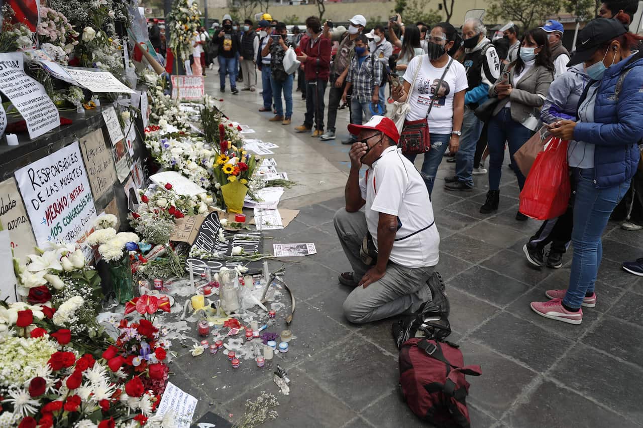 Citizens pay tribute at the place where university students died from pellets fired by the police during protests.