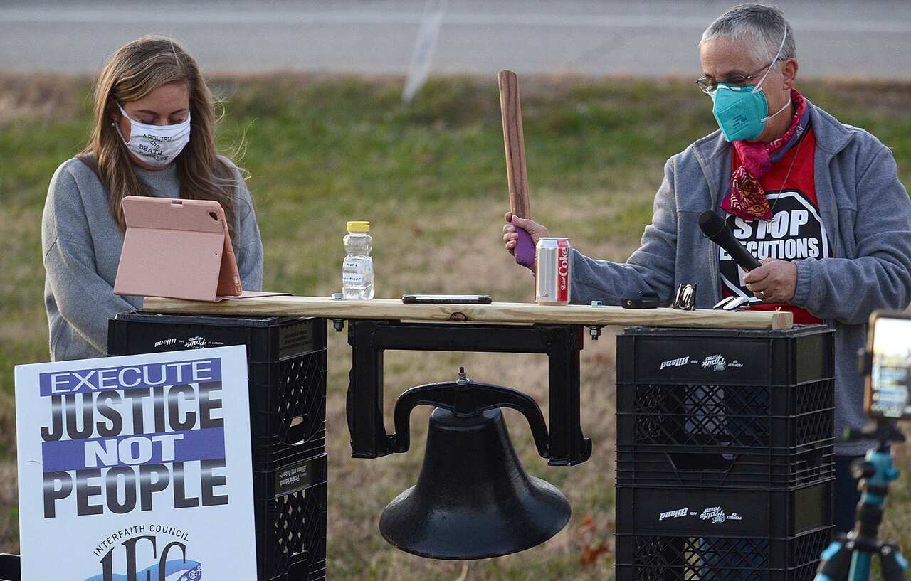 Sister Barbara Battista, right, tolls a bell before a minute of silence during the protest of the execution of Orlando Hall on Thursday.