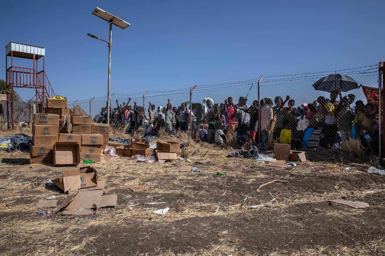 People who fled the conflict in Ethiopia's Tigray region wait for UNHCR to distribute blankets at Hamdayet Transition Center, eastern Sudan.