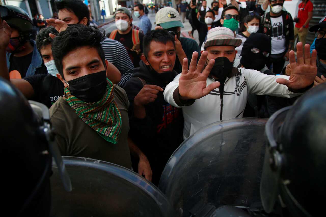 Clashes between the Police (front) and protesters after hundreds of the latter broke into Guatemala's Lower House and sat it on fire on 22 November, 2020.