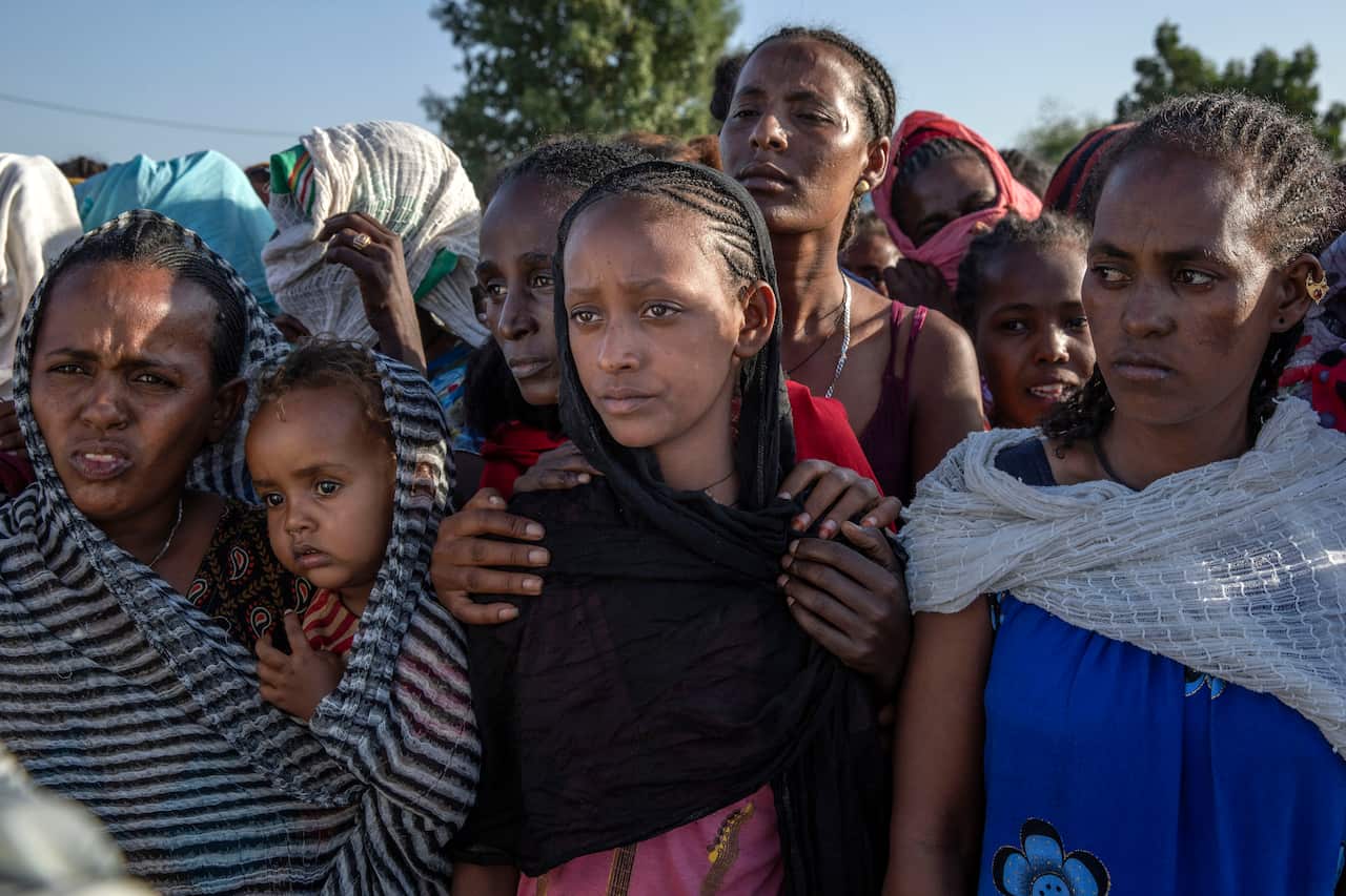 Tigray women who fled the conflict in Tigray wait to receive aid at Village 8, the transit centre near the Lugdi border crossing, eastern Sudan in November 2020