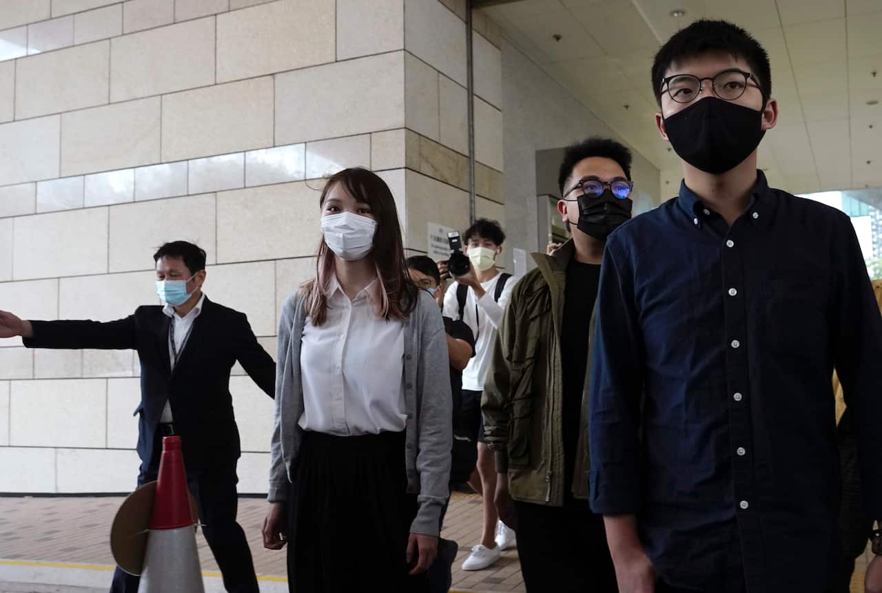 Hong Kong activists, from right, Joshua Wong, Ivan Lam and Agnes Chow arrive at a Hong Kong court.