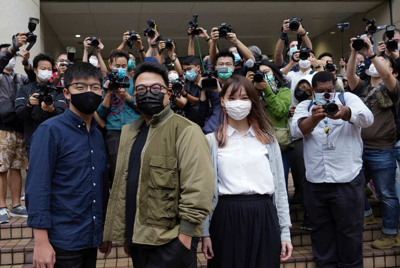 Hong Kong activists, from left, Joshua Wong, Ivan Lam and Agnes Chow arrive at a Hong Kong court.