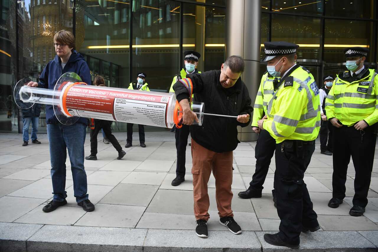 Demonstrators hold a large syringe while protesting against COVID-19 vaccination, outside the headquarters of the Bill and Melinda Gates Foundation in London.