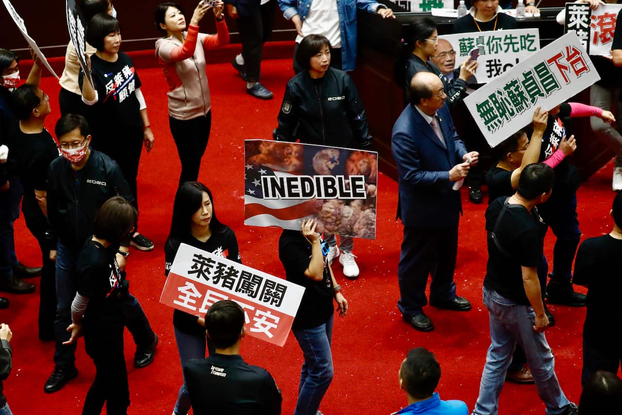 Lawmakers from Taiwan's Kuomintang (KMT) party hold placards during a protest inside the parliament in Taipei, Taiwan.