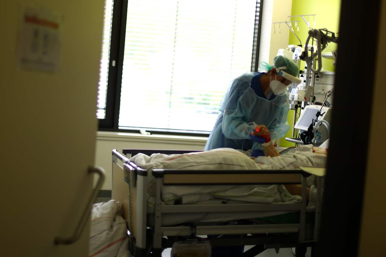 A nurse assists a COVID-19 patient at one of the intensive care units of the hospital in Muehldorf am Inn, Germany. 