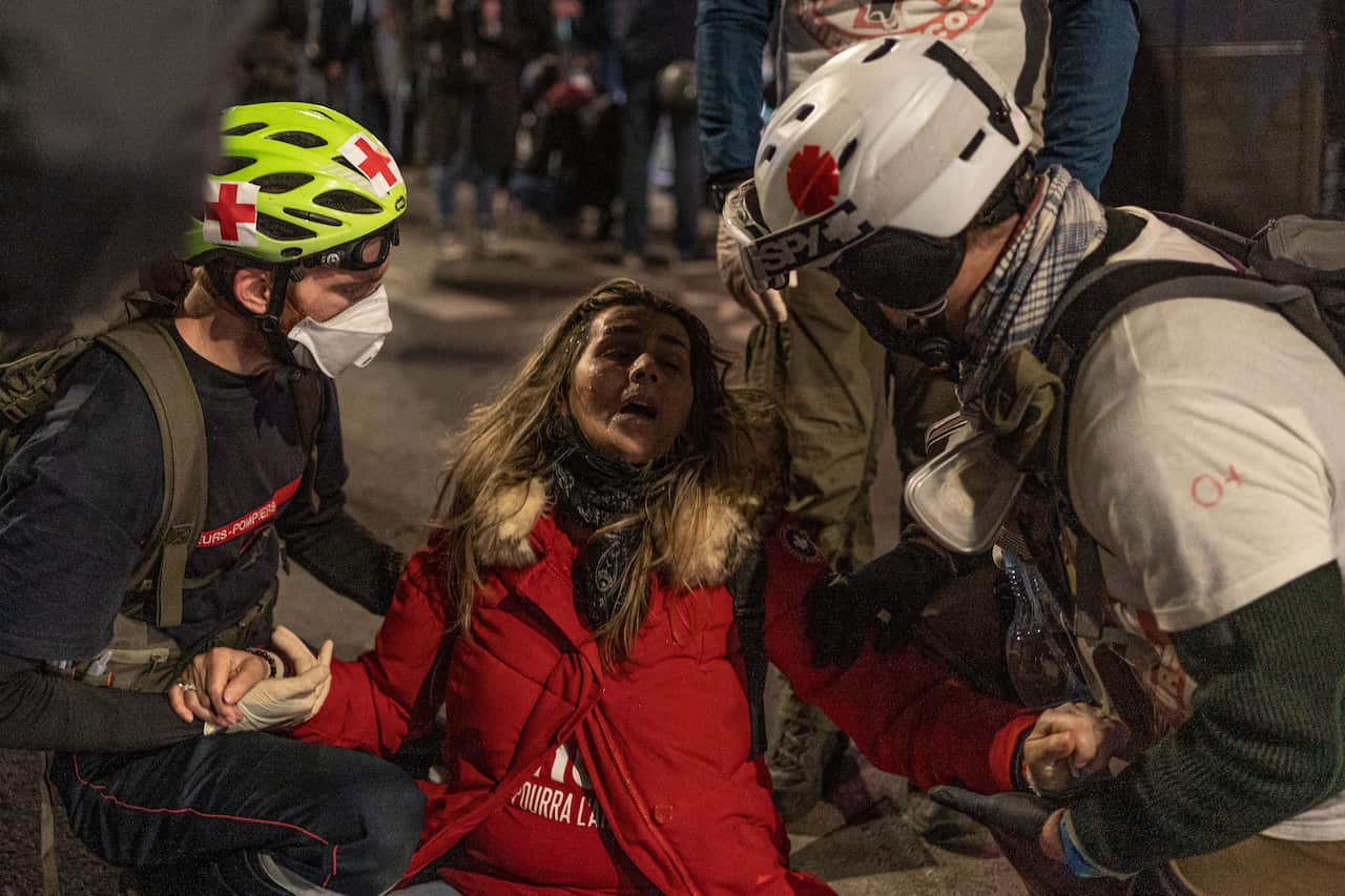 A woman reacts to tear gas during a demonstration against the 'global security' draft law in Paris on 28 November.
