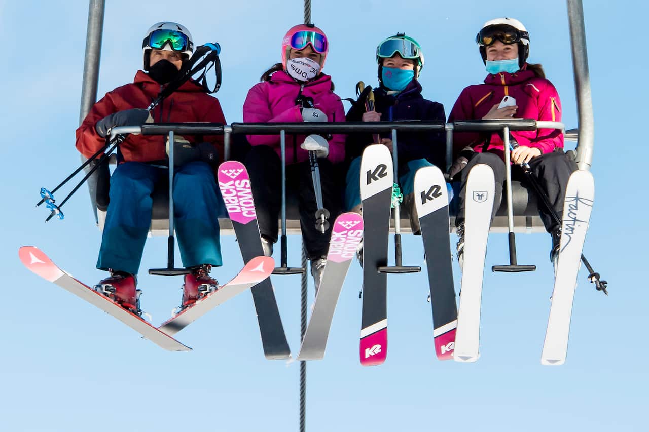 Skiers wearing face masks ride a chairlift at the Verbier ski area in the Swiss Alps.