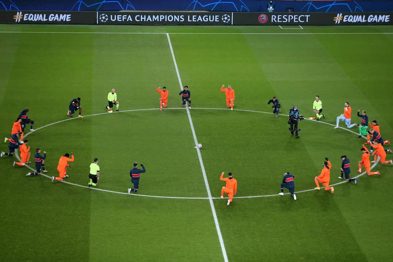 Players of Paris Saint-Germain and Istanbul Basaksehir take a knee before the start of the match