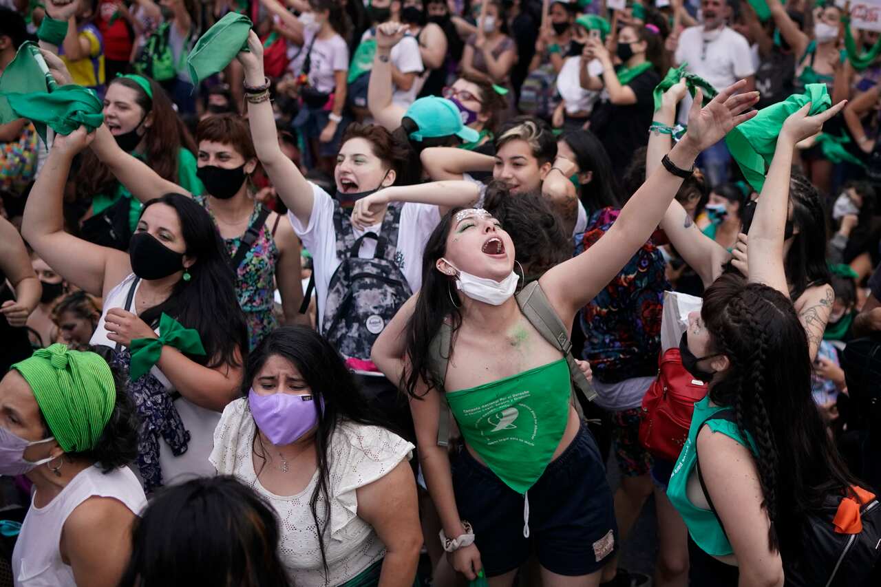 Abortion-rights activists shout slogans outside Congress in Buenos Aires, Argentina, Friday, Dec. 11, 2020. The Argentine lower house has approved a bill that would legalize abortion. The bill now moves to the Senate.