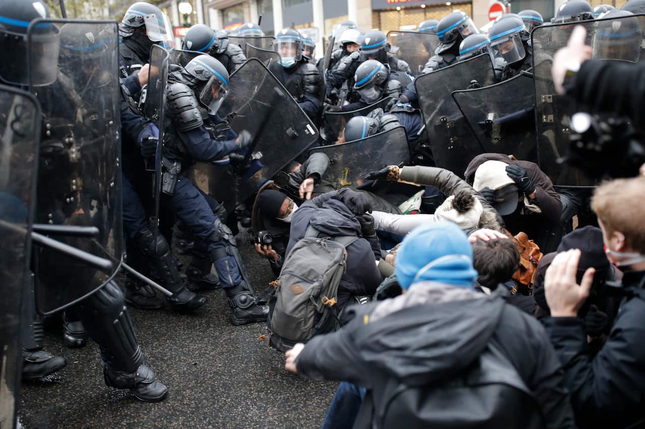Riot police officers confront a group of protesters 