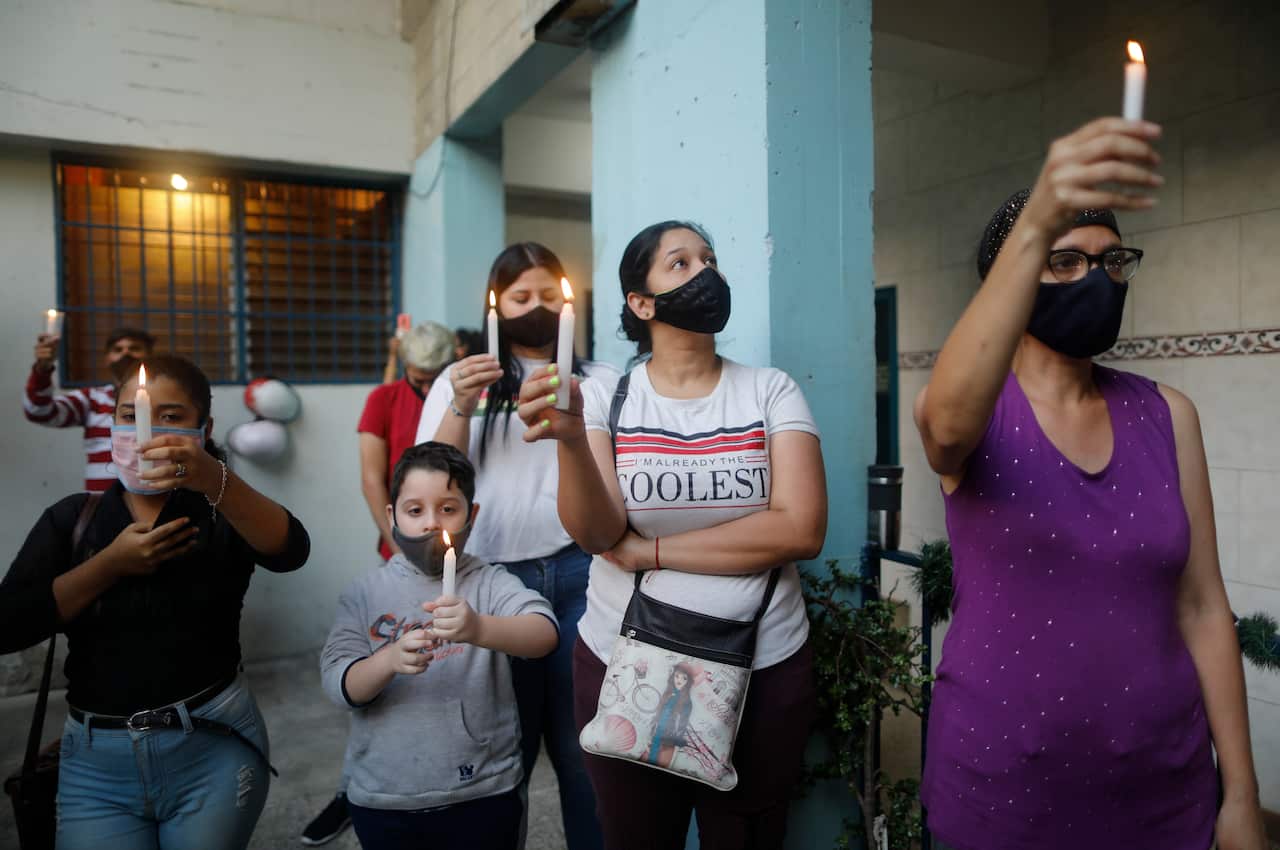 Mourners hold candles in Caracas, Venezuela, at a vigil for victims found drowned this past weekend attempting to reach Trinidad and Tobago.