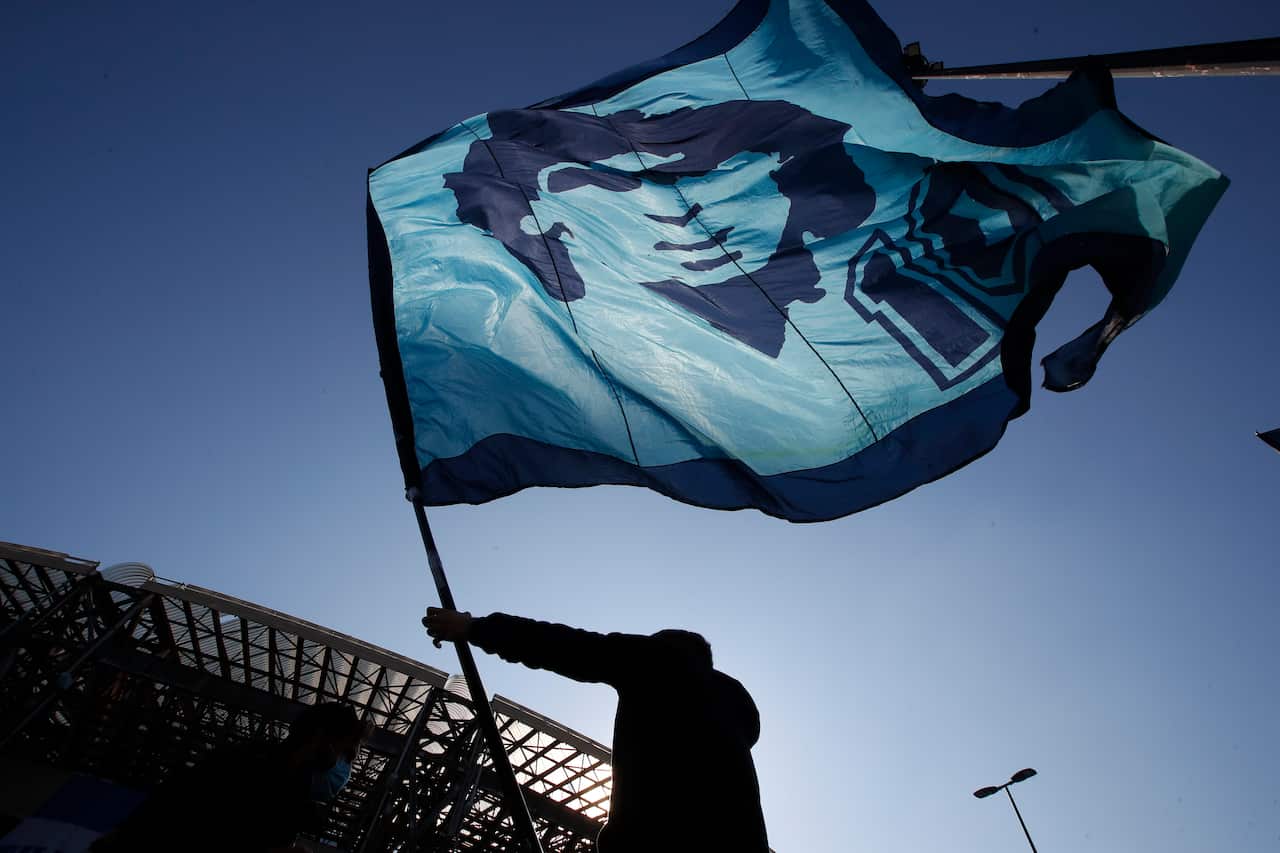 A man waves a flag commemorating soccer legend Diego Maradona outside the San Paolo stadium.