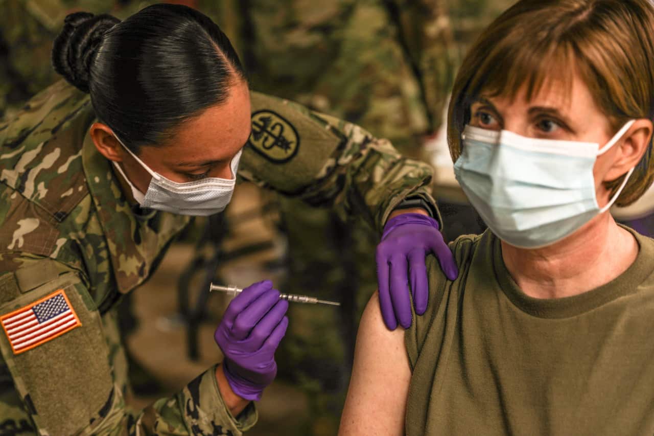 Staff Sgt. Brenda Collins, medical specialist, administers the COVID-19 vaccination.