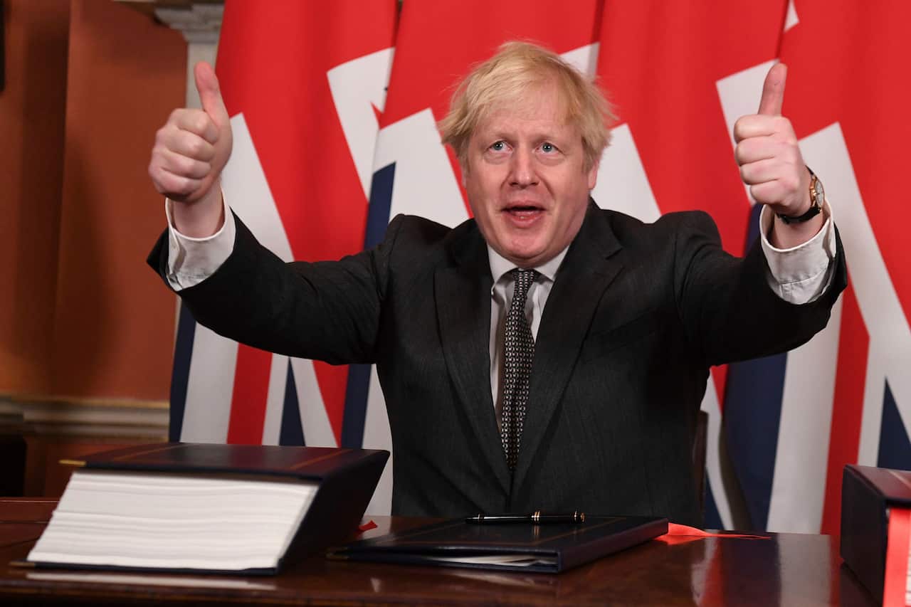 Boris Johnson gives a thumbs up gesture after signing the EU-UK Trade and Cooperation Agreement.