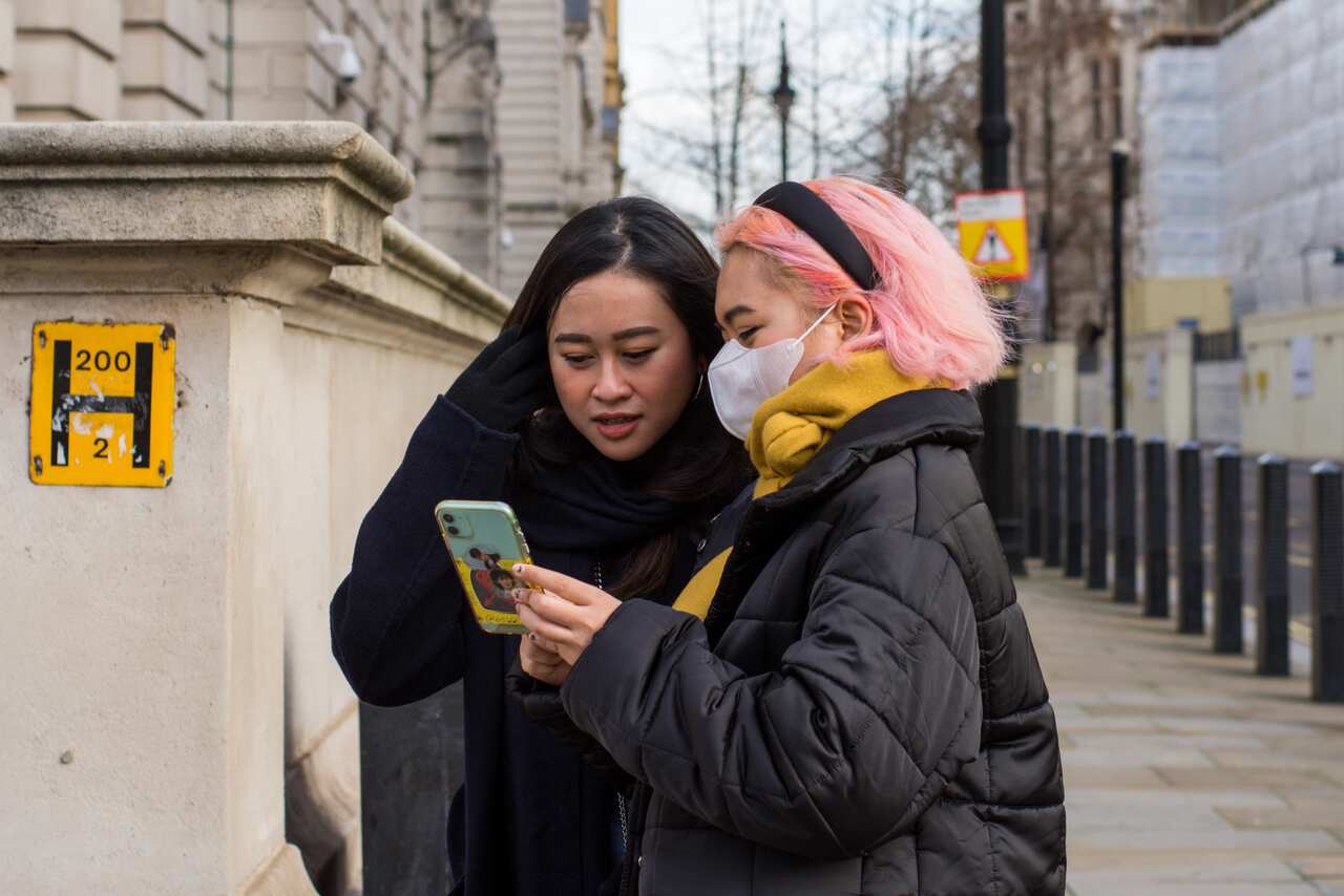 Women use a smartphone of the street.