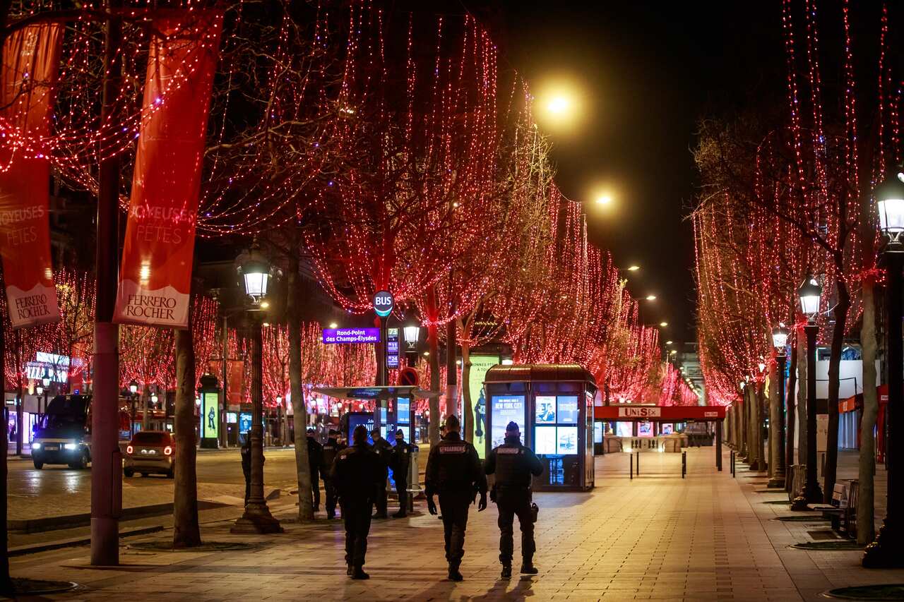 French police forces patrol the Champs-Elysees during New Year eve, in Paris amid security measures to restrain celebrations due to COVID-19.