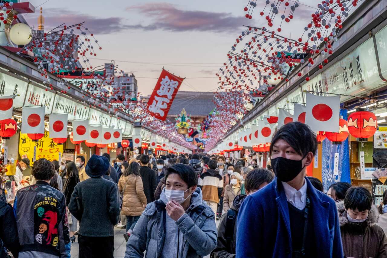 People wearing masks as a preventive measure against the spread of COVID-19 visit Tokyo's Senso-ji Temple to offer new year's prayers.