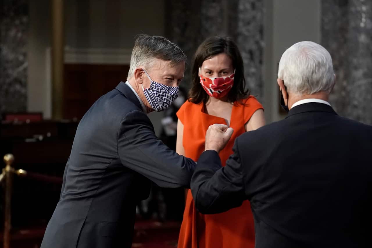 Senator John Hickenlooper greets Vice President Mike Pence  as he takes the oath of office during a  ceremony in Washington, DC, 3 January 2021.  