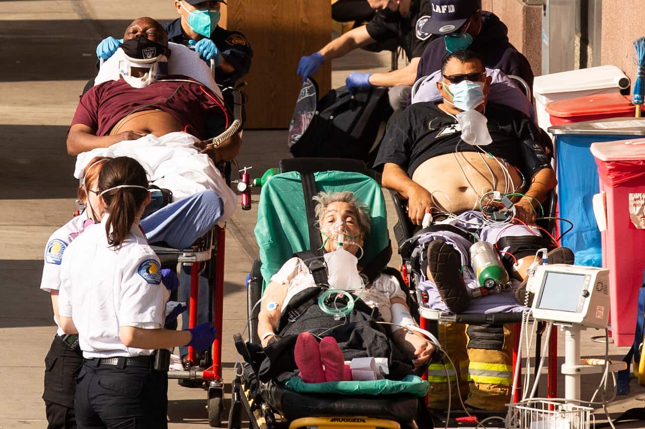 Patients wait outside the Emergency Room as they are brought in by an ambulance and the fire department at a Los Angeles hospital.