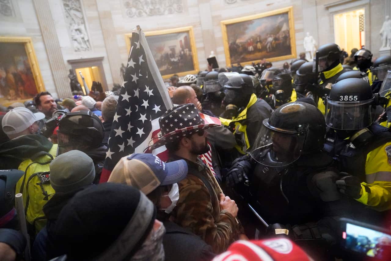 Protestors storm the Capitol building during a joint session of Congress in Washington, DC .