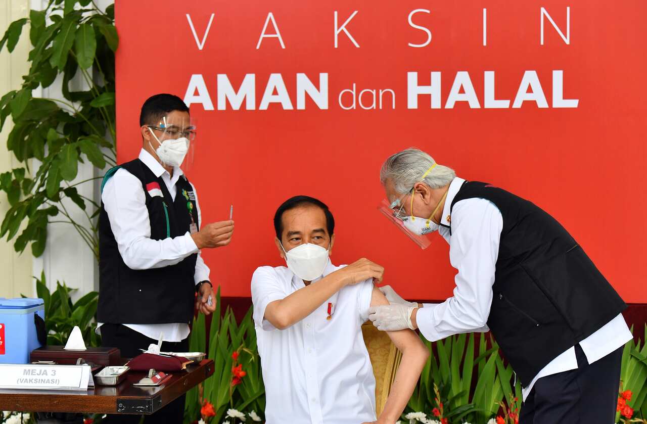 Indonesian President Joko Widodo rolls up his sleeve to receive a COVID-19 vaccine on live television.