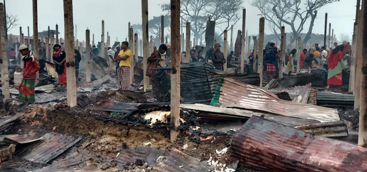 Rohingya refugees walk in the charred remains after a fire broke out in Nayapara Camp in Coxs Bazar district, Bangladesh.