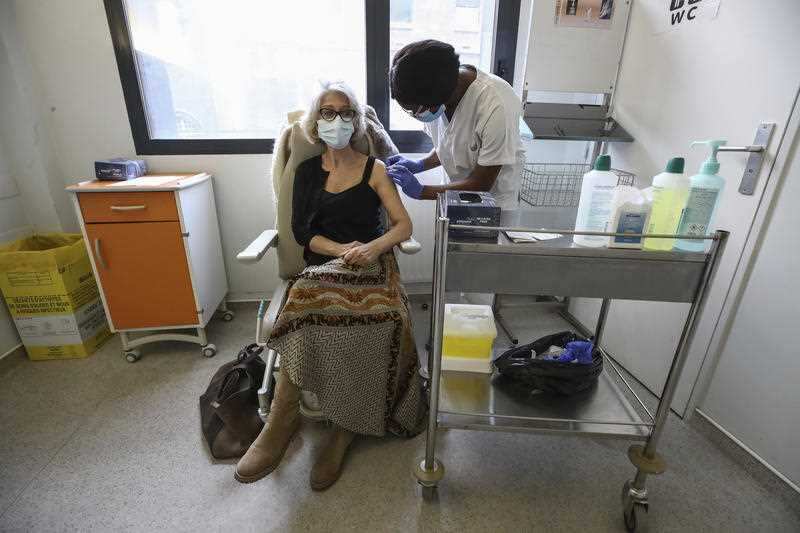 The Biontech/Pfizer vaccine is administered to a medical professional at a hospital in Paris. 