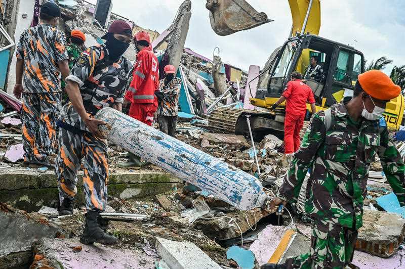 Soldiers clear away debris while looking for victims. 