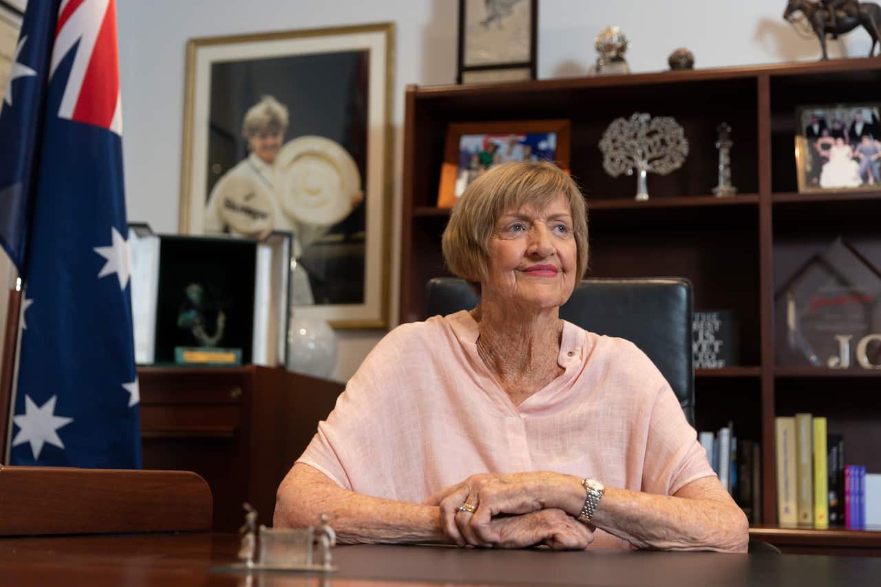 Margaret Court poses for a portrait in her office, 22 January 2021, with a photograph of her she won Wimbledon in 1965.