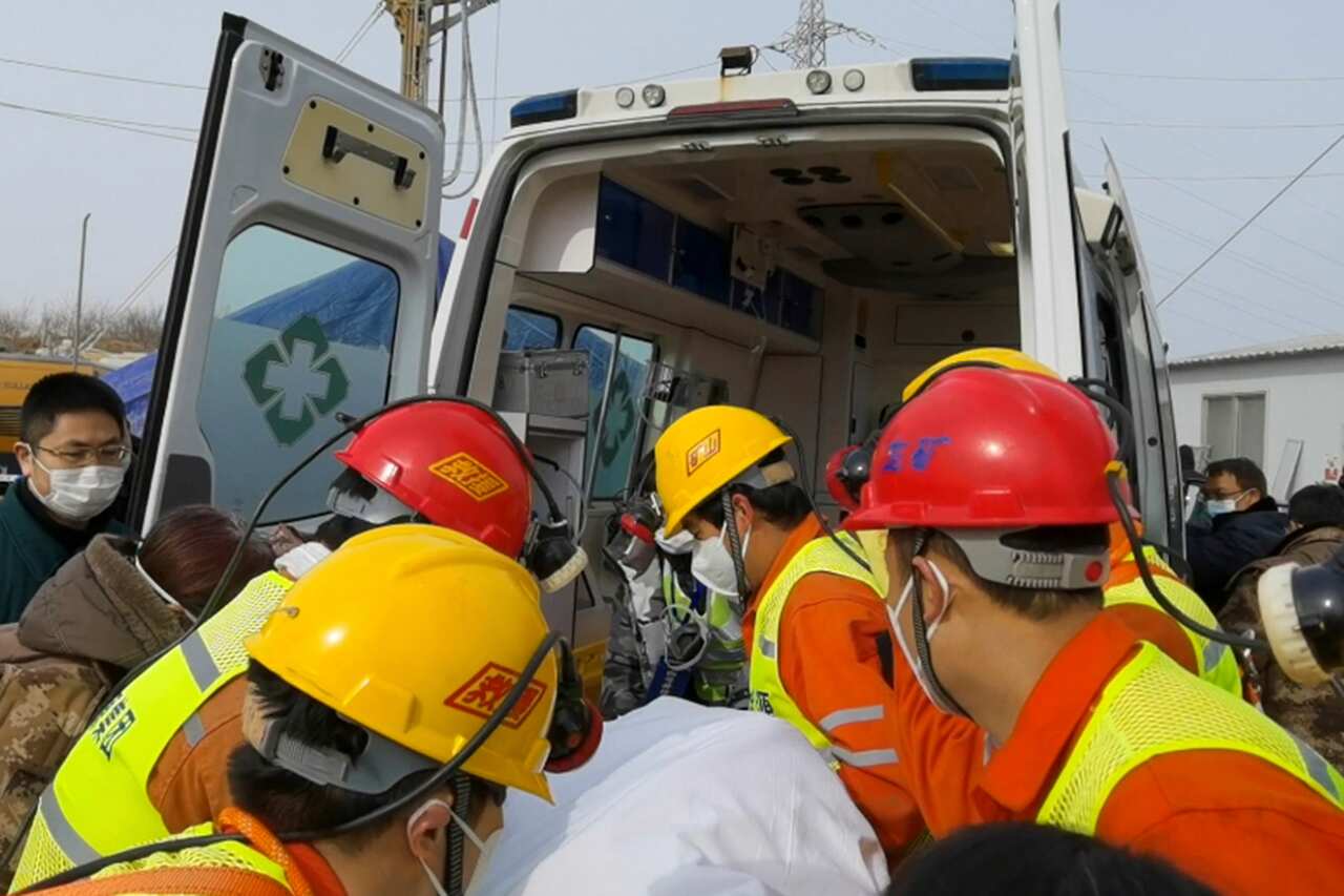 In this photo released by Xinhua News Agency, rescuers carry a trapped miner to an ambulance in Qixia City in east China's Shandong Province on Sunday.