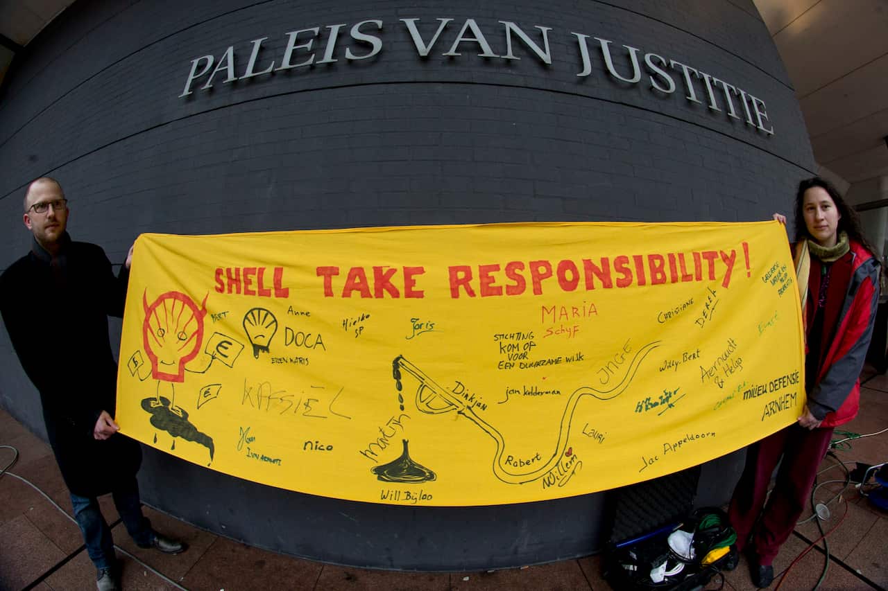 Friends of the Earth activists hold a banner outside court ahead of the case of Nigerian farmers against Shell in 2013.